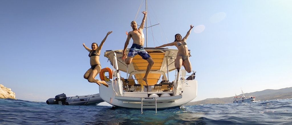 croisière en bateau à athènes, groupe de personnes sautant dans la mer d'un bateau avec skipper