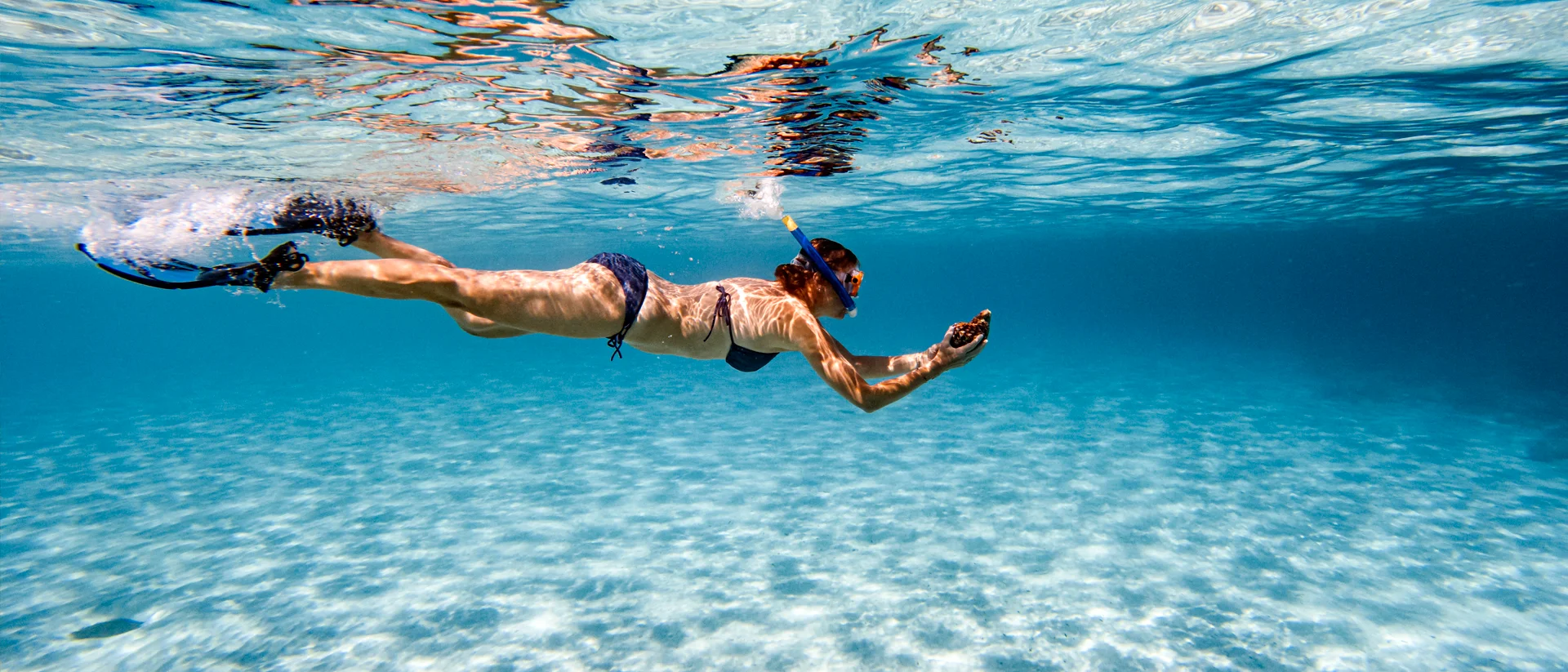 Frau taucht im kristallklaren Wasser im Urlaub auf Korfu