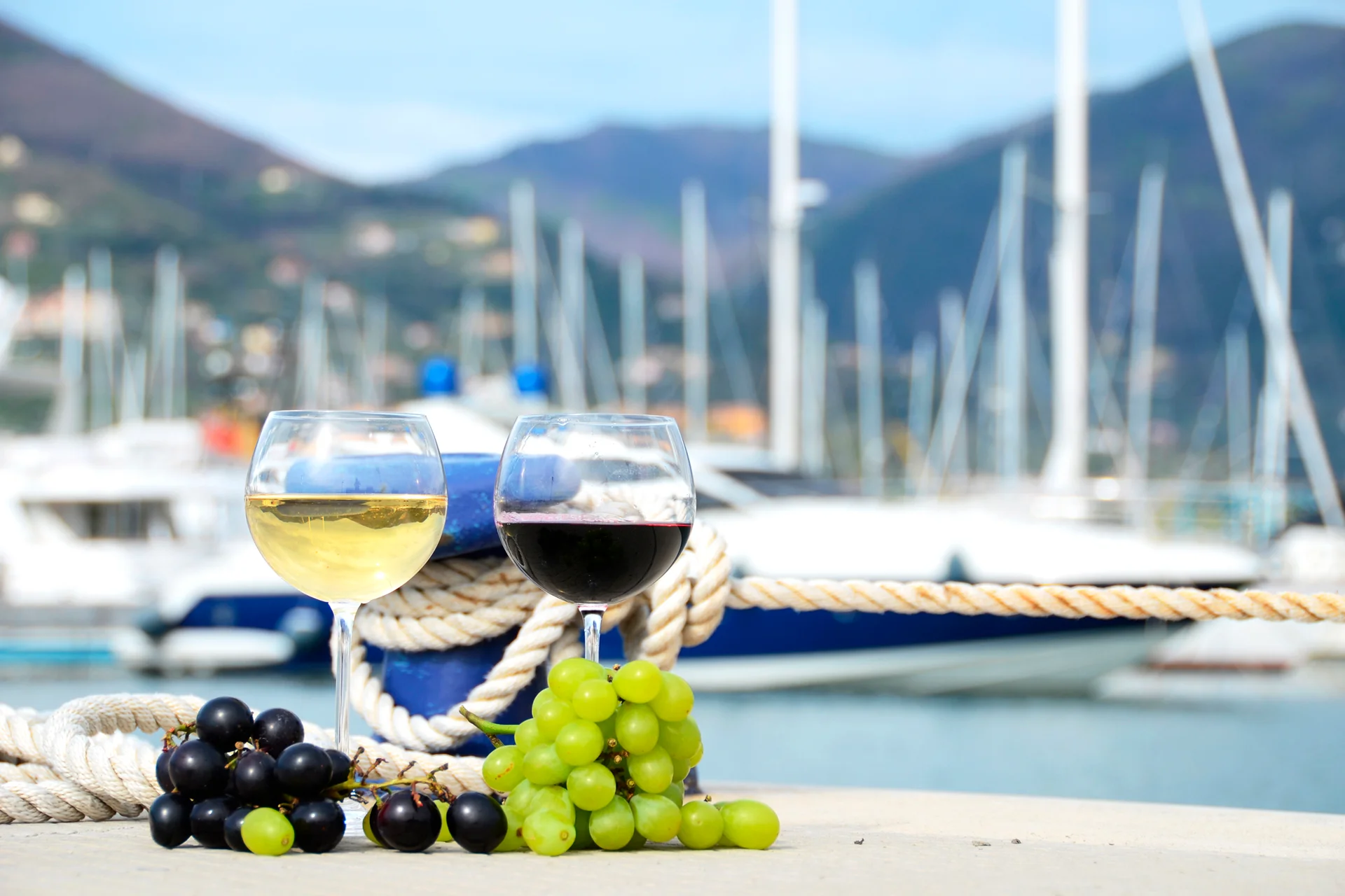 Italien: Wein und Trauben im Hafen, festgemachte Yachten