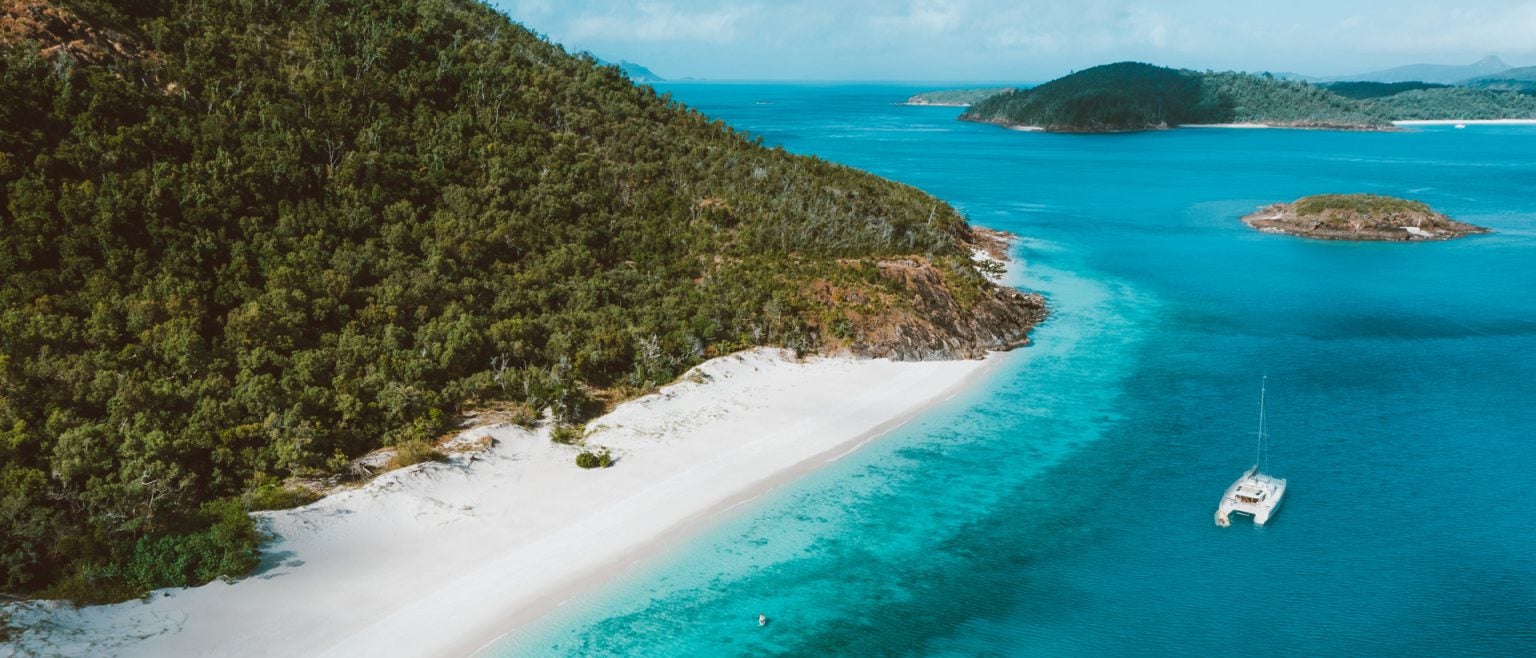 sailing catamaran near beach in Whitsunday Islands, Australia