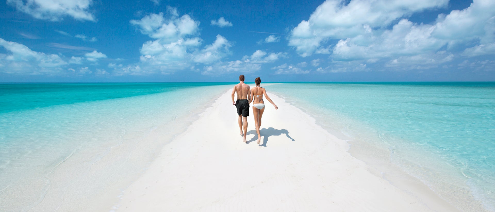 Pareja disfrutando de sus vacaciones en las azules aguas de la costa de Exuma