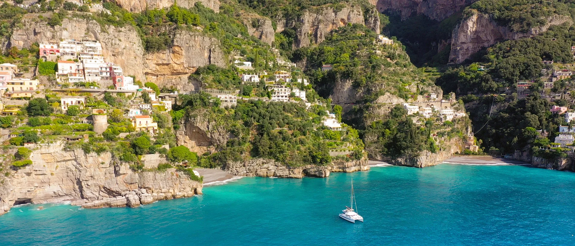 Blaue Küste mit Klippen bei Katamarancharter in Neapel