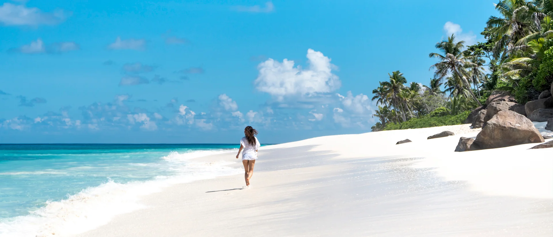 Chica viviendo aventuras en una playa blanca en Seychelles