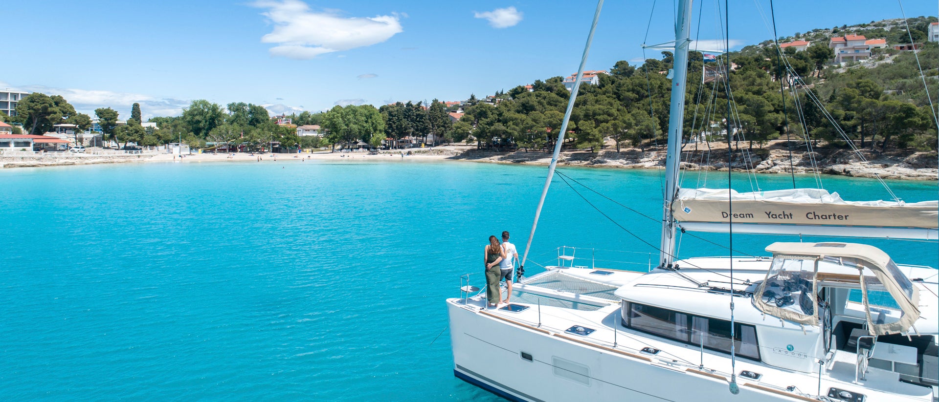 Una pareja navega felizmente en una embarcación de alquiler junto a la playa por Šibenik