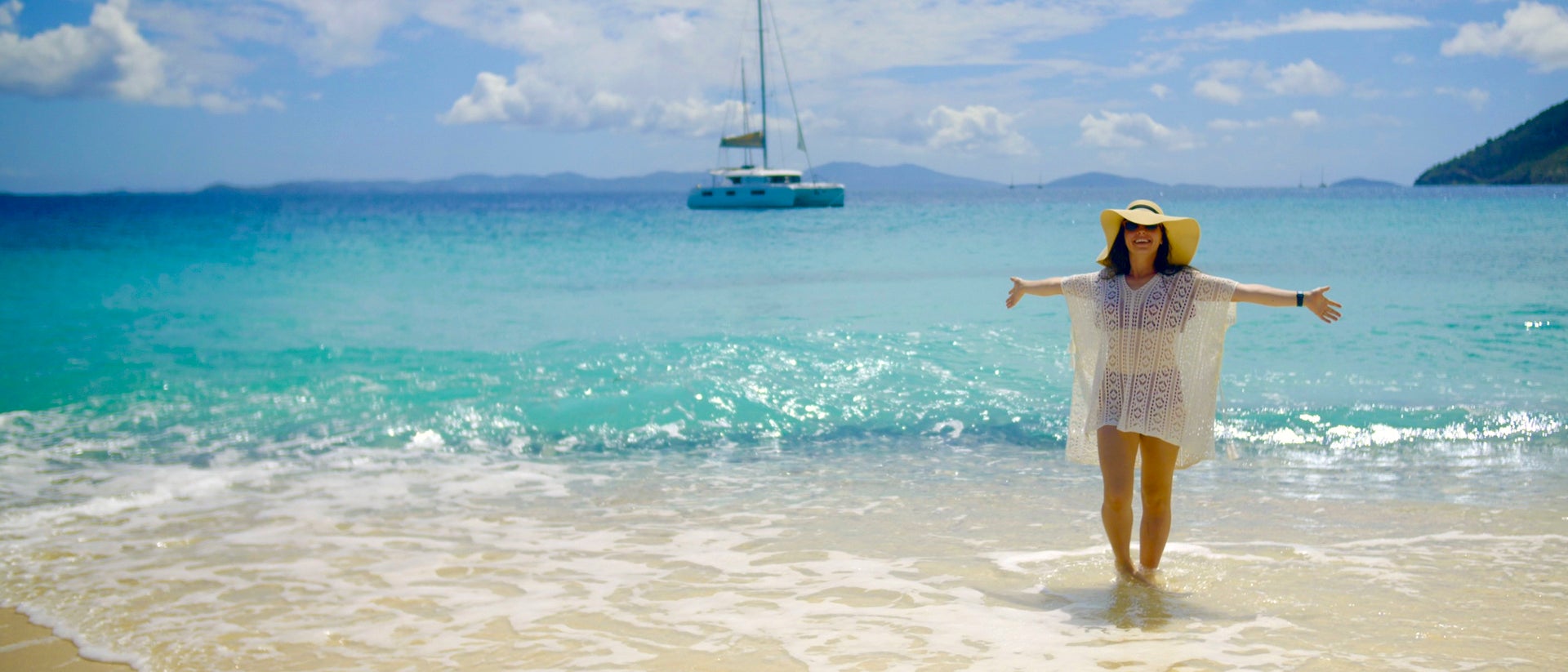 Chica feliz en una playa durante un viaje a bordo de un catamarán de alquiler por Lavrio