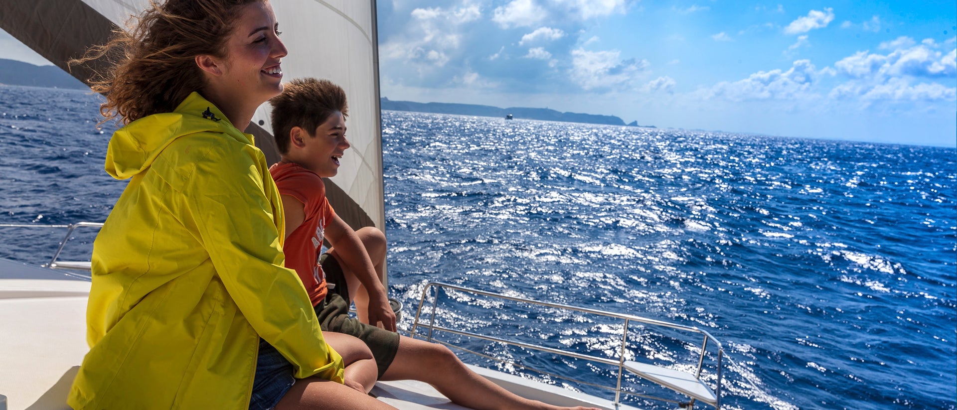 Famiglia felice che si gode le vacanze in barca a vela in Sicilia