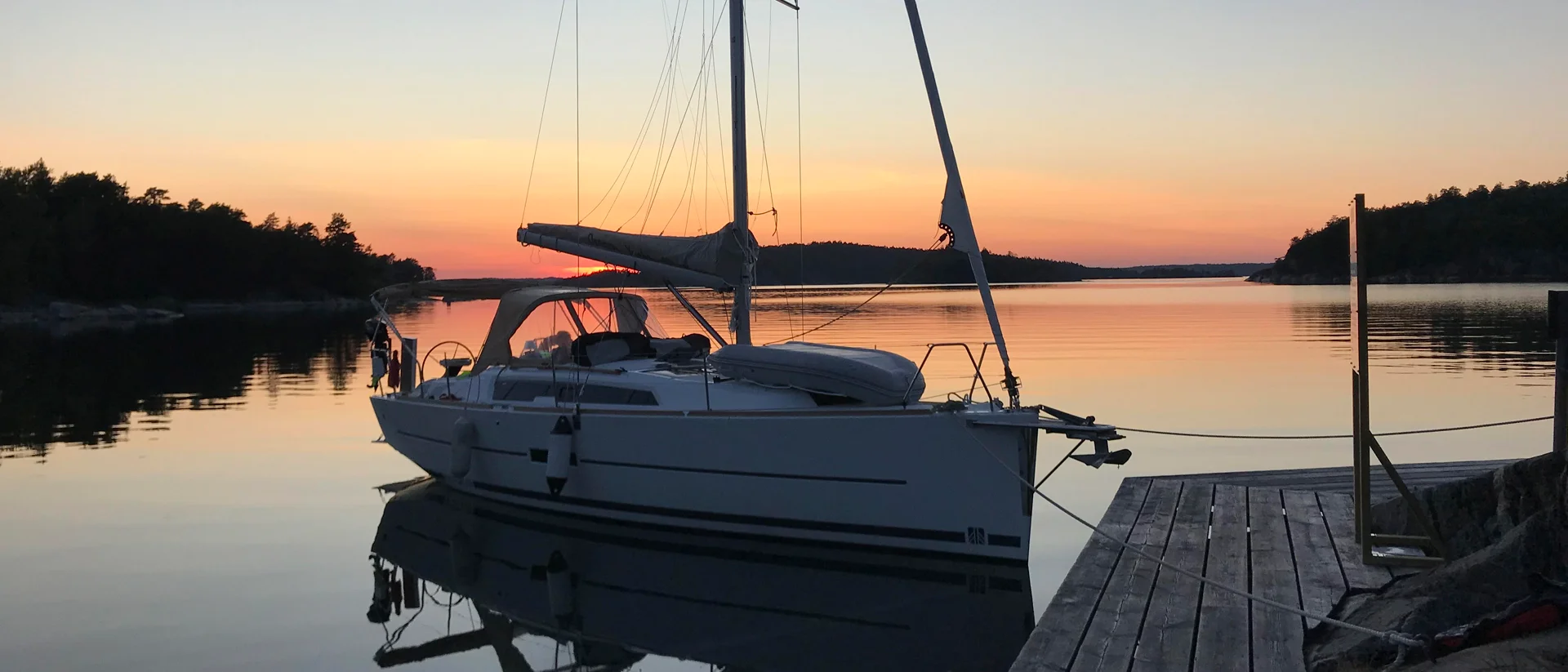 Zeilbootcharter bij zonsondergang in een fjord van Zweden