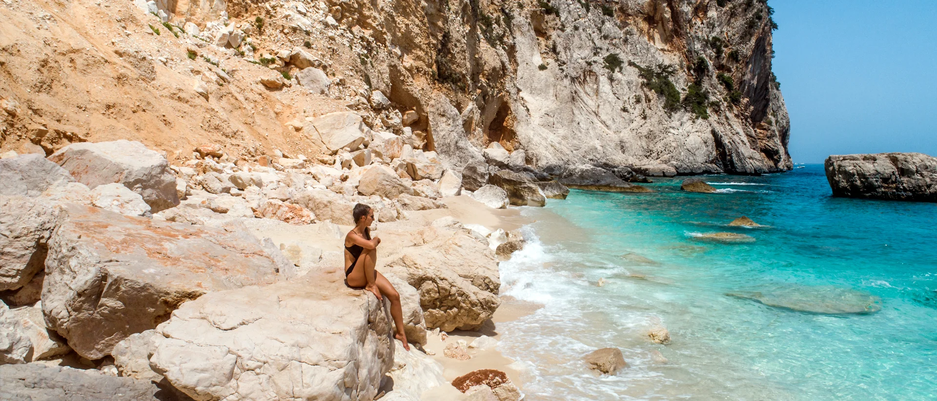 Ragazza che si rilassa su una spiaggia naturale durante le vacanze in barca a vela in Sardegna
