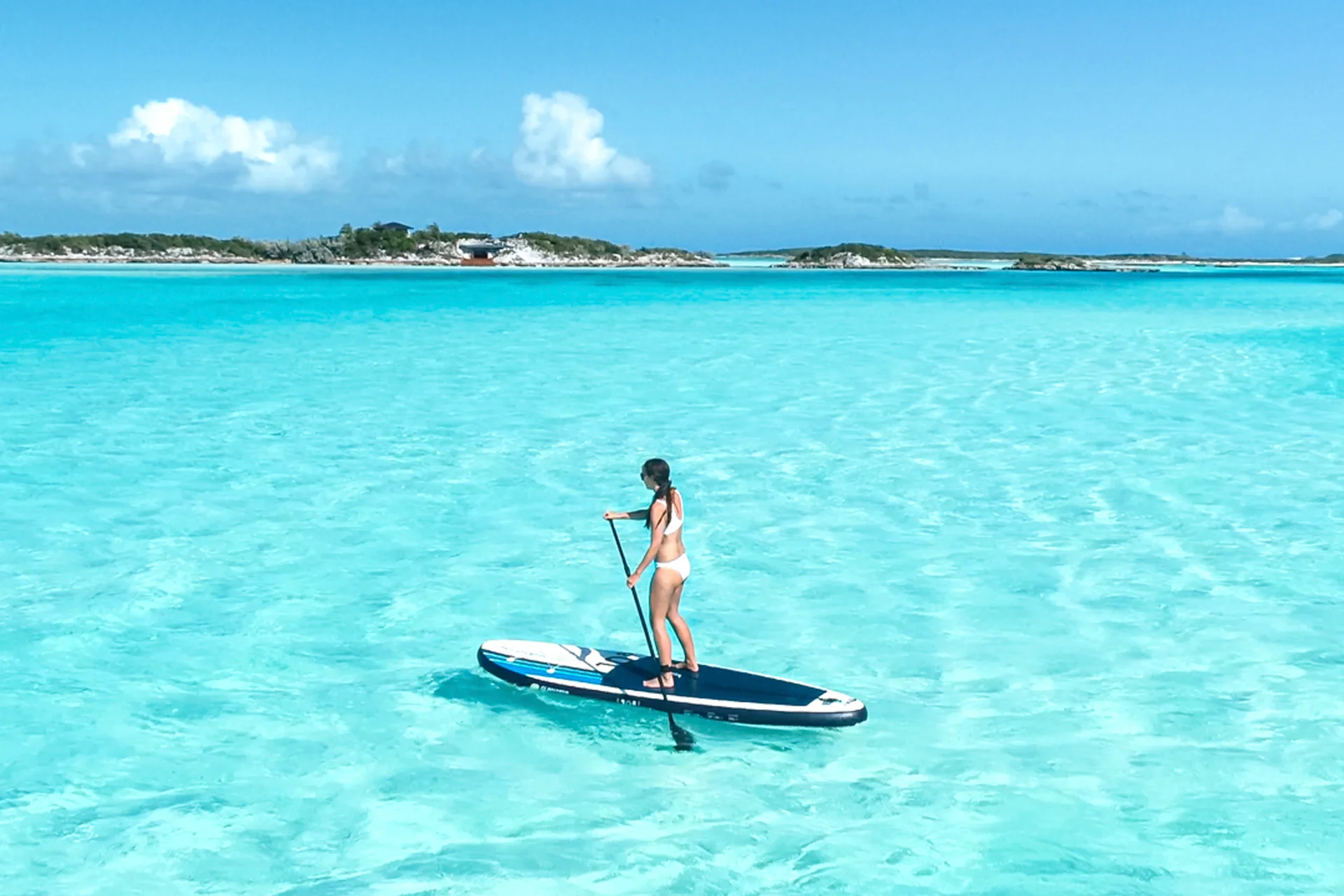 Frau auf den Bahamas auf dem Surfbrett genießt ihren Segelurlaub