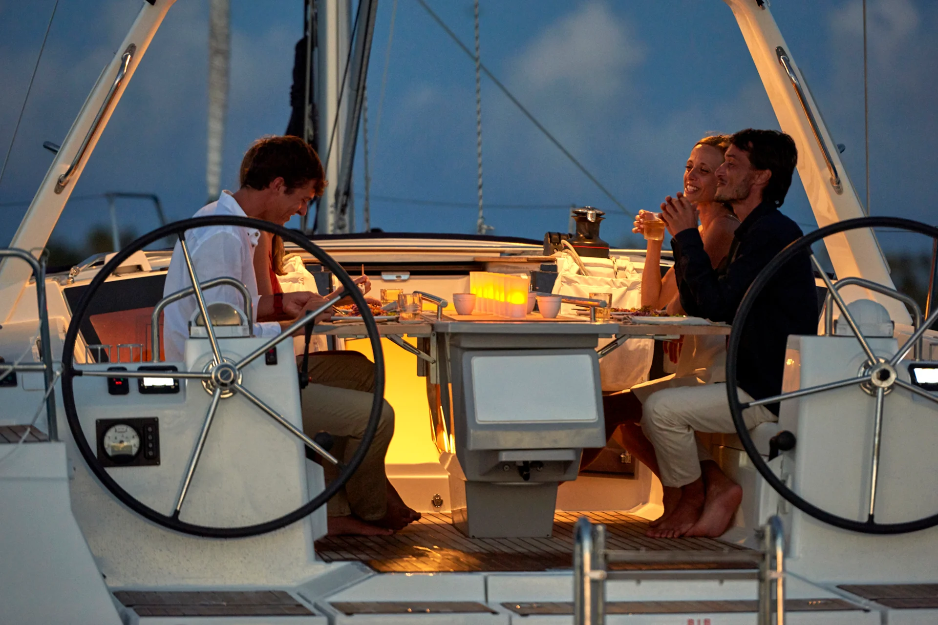Amici felici che si godono le vacanze in barca a vela a Tahiti