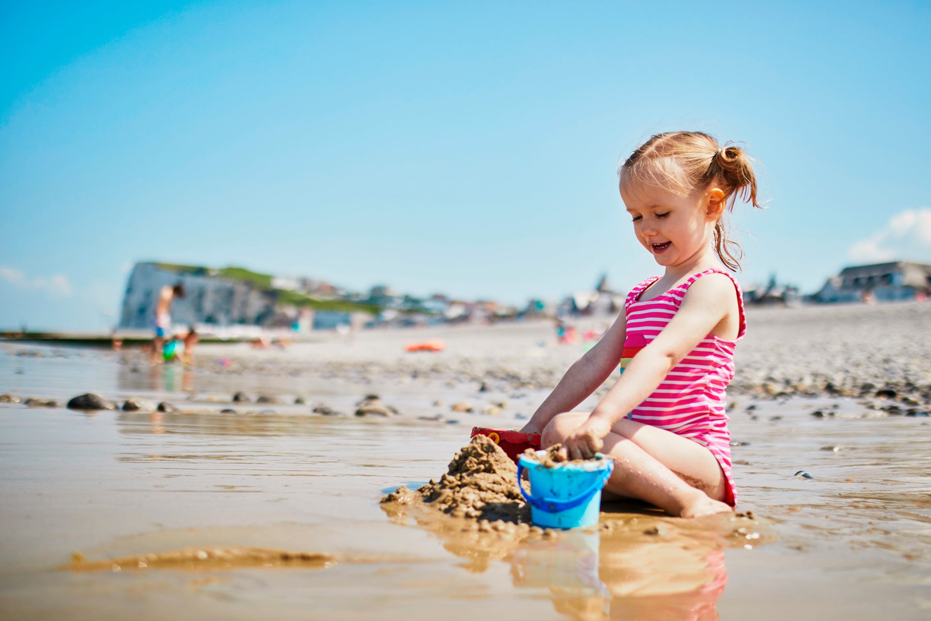 Niño jugando en la playa durante las vacaciones de verano en Bretaña