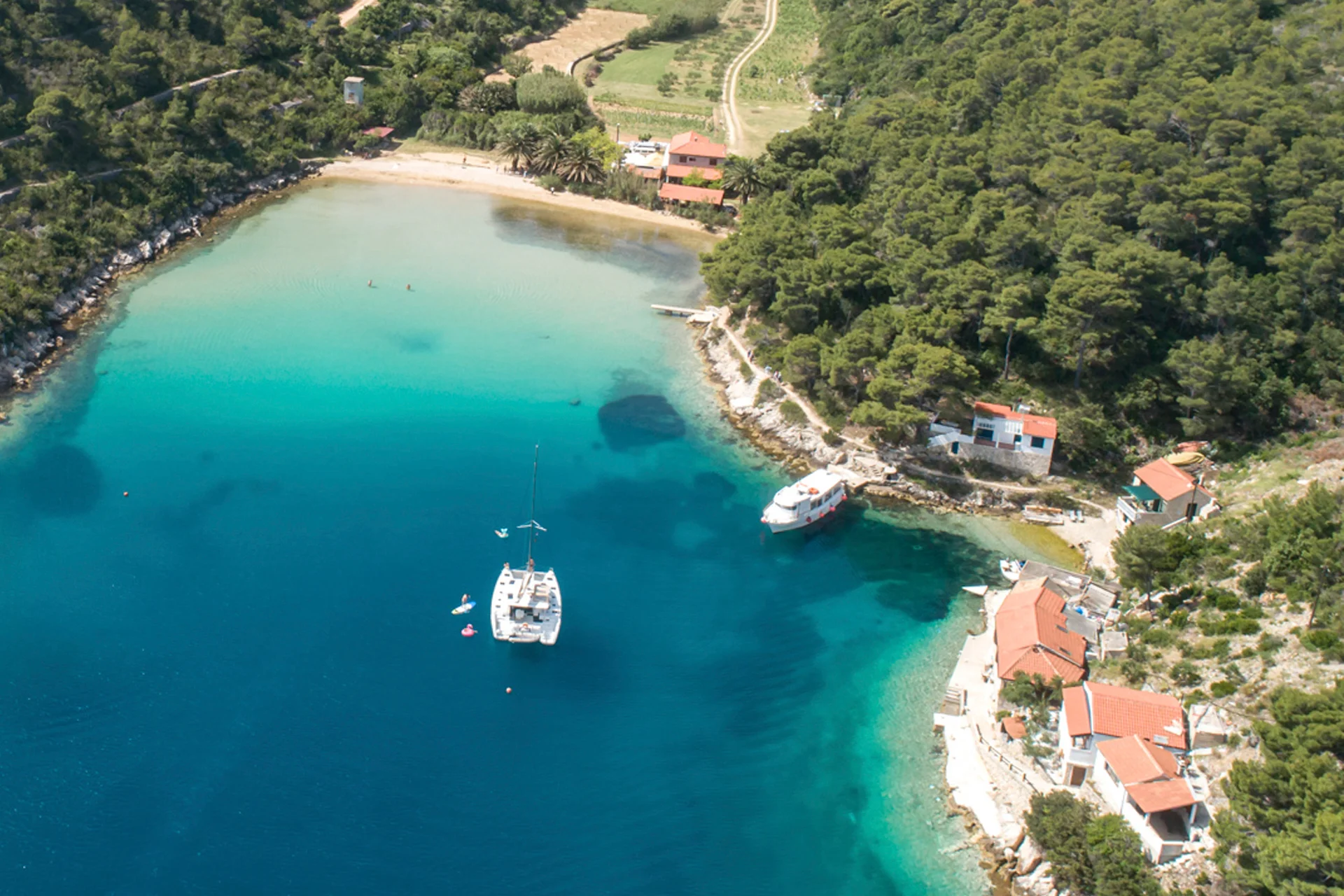 Catamarano e yacht charter in una baia sulle acque cristalline della Croazia