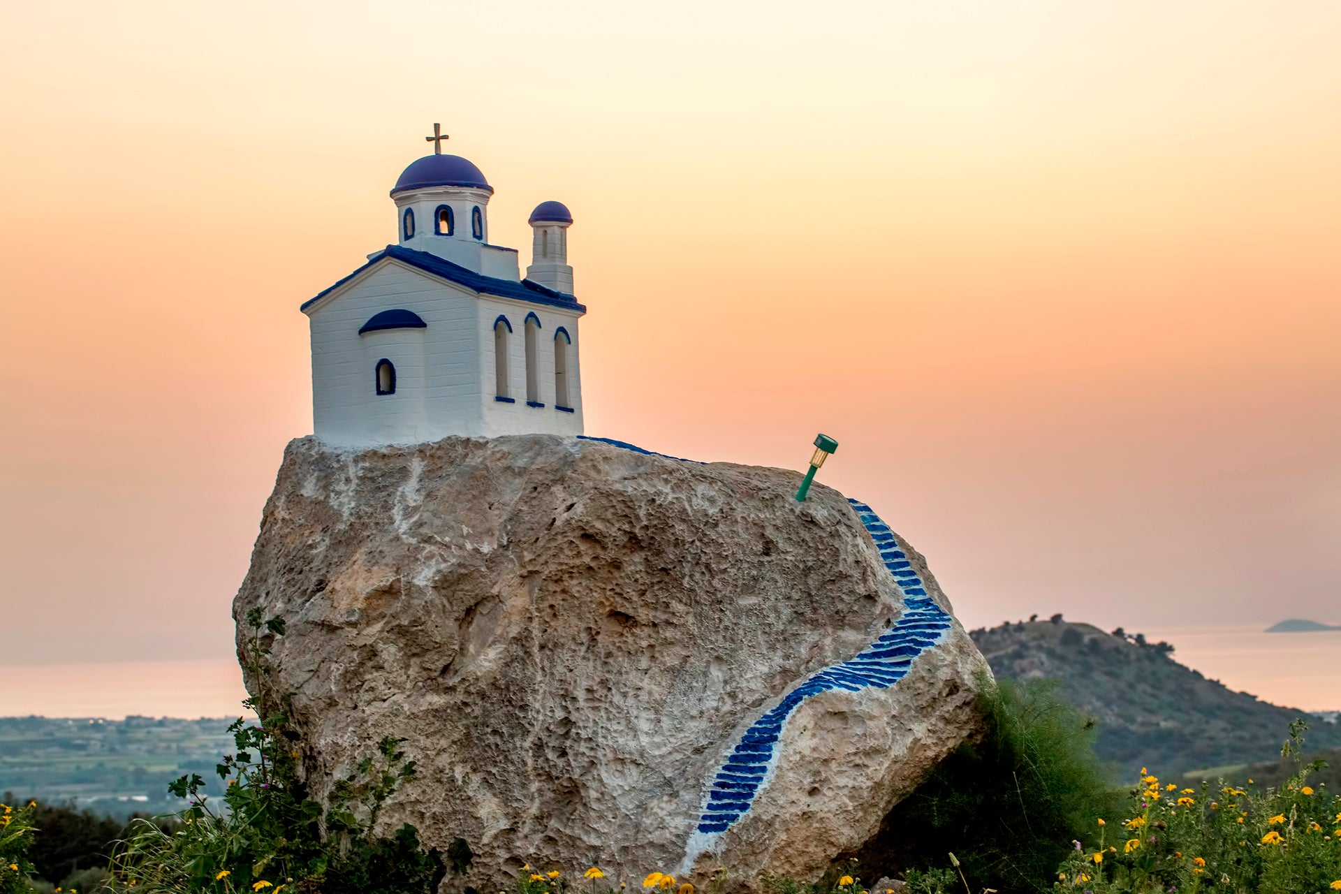 Un bellissimo tramonto con una chiesa sui monti di Kos