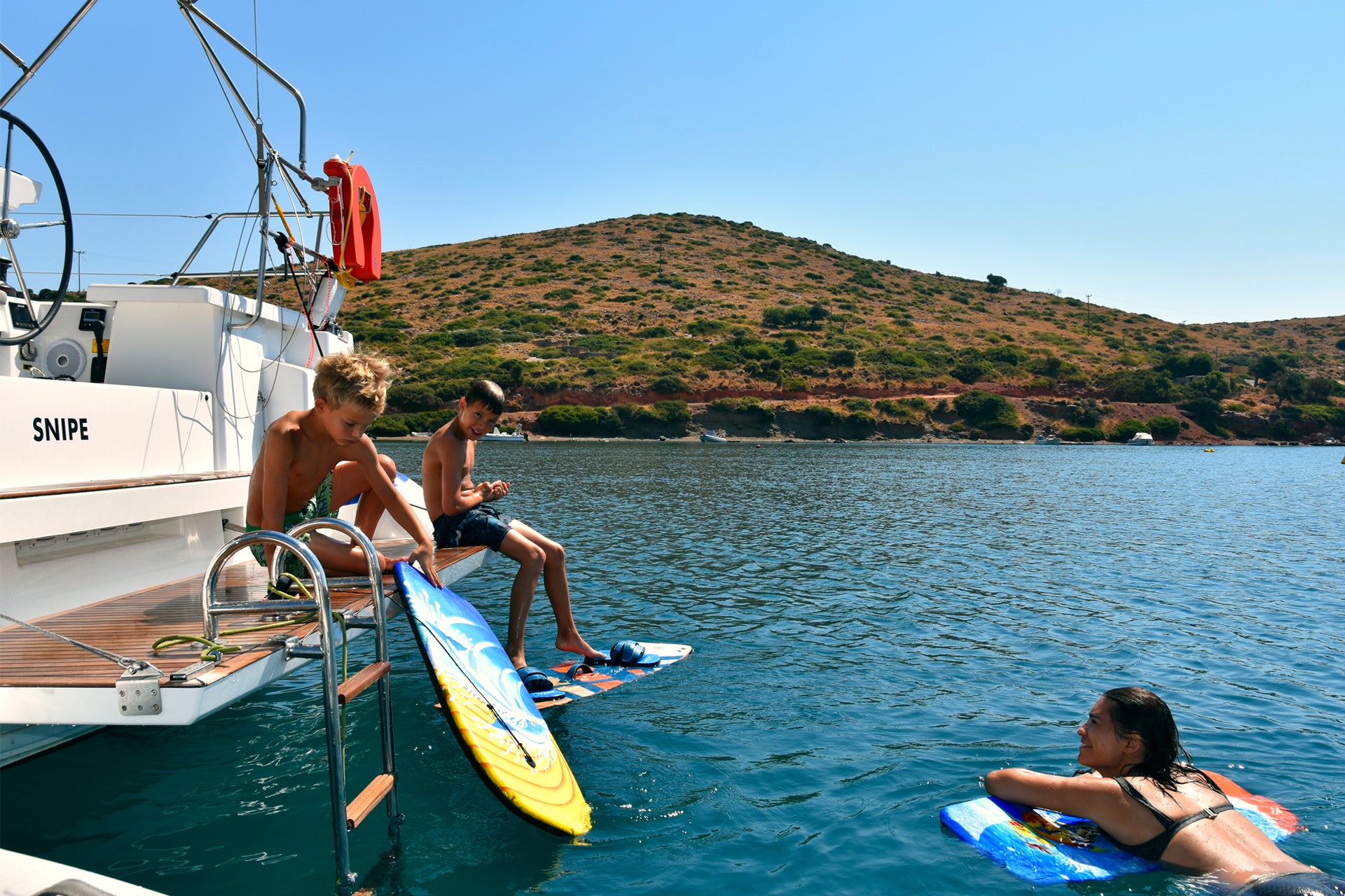 Famiglia felice che fa surf durante le vacanze in barca a vela a Kos