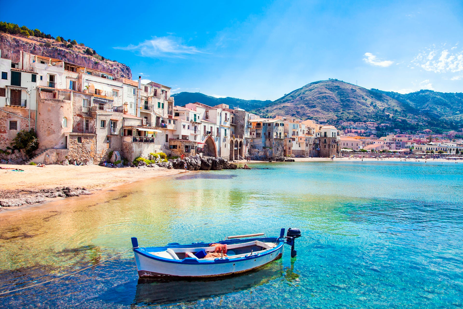 Voilier au large d'une plage aux eaux cristallines, vieille ville en Sicile