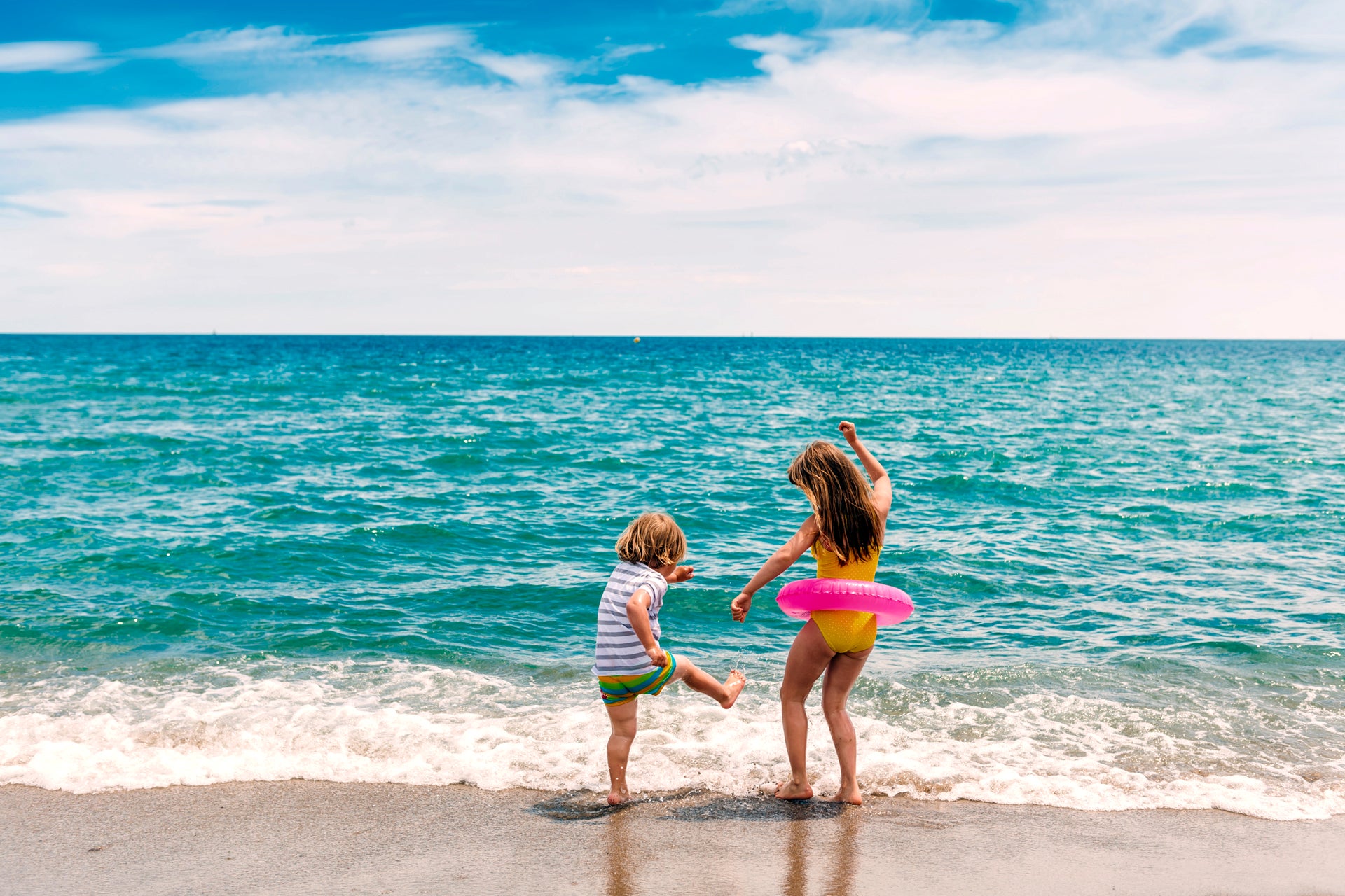 Bambini al mare che si godono le vacanze in barca a vela in Spagna