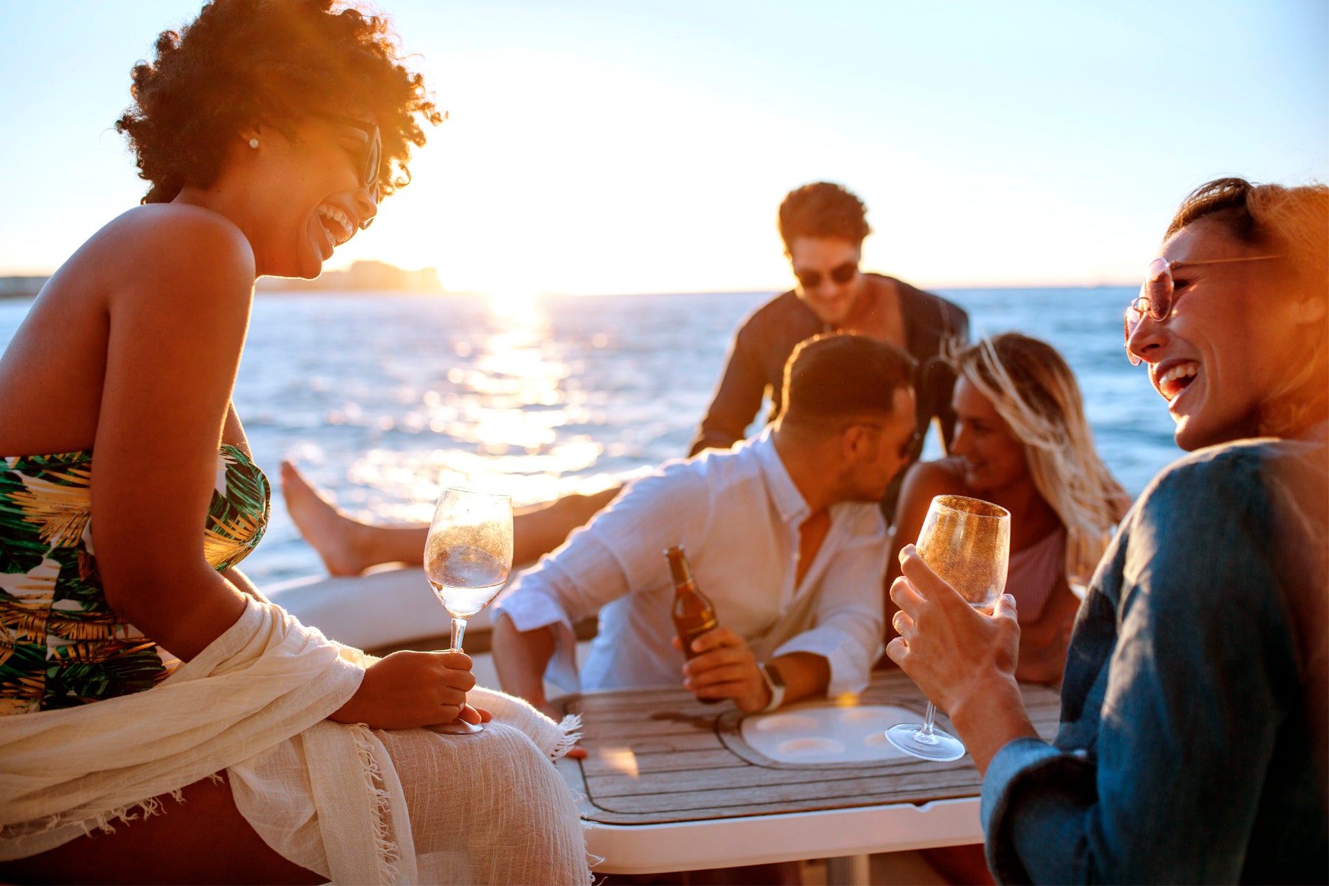 Amigos navegando a bordo de un yate de alquiler al atardecer en Tenerife