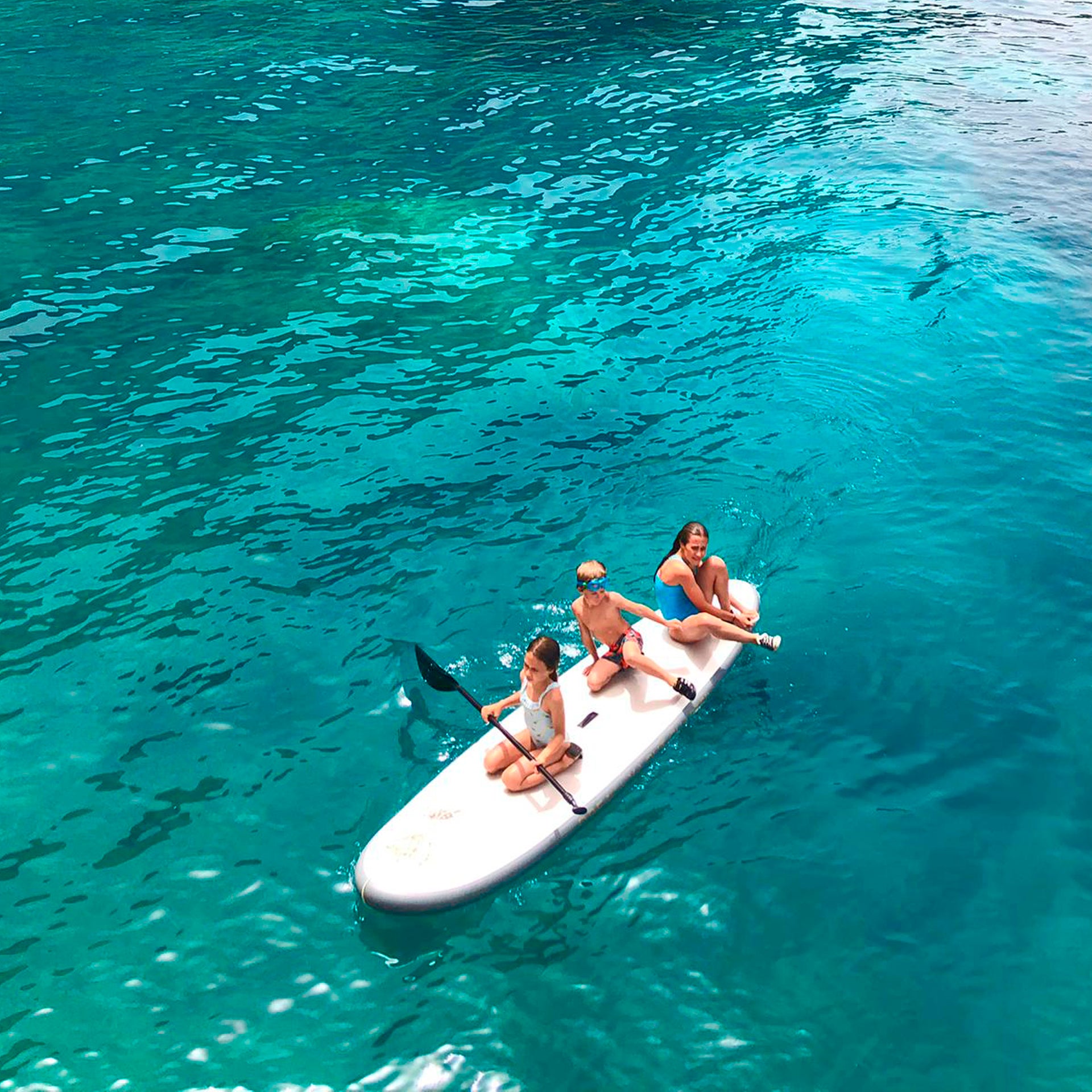 Kos blije familie paddle board surfen zomer helder water