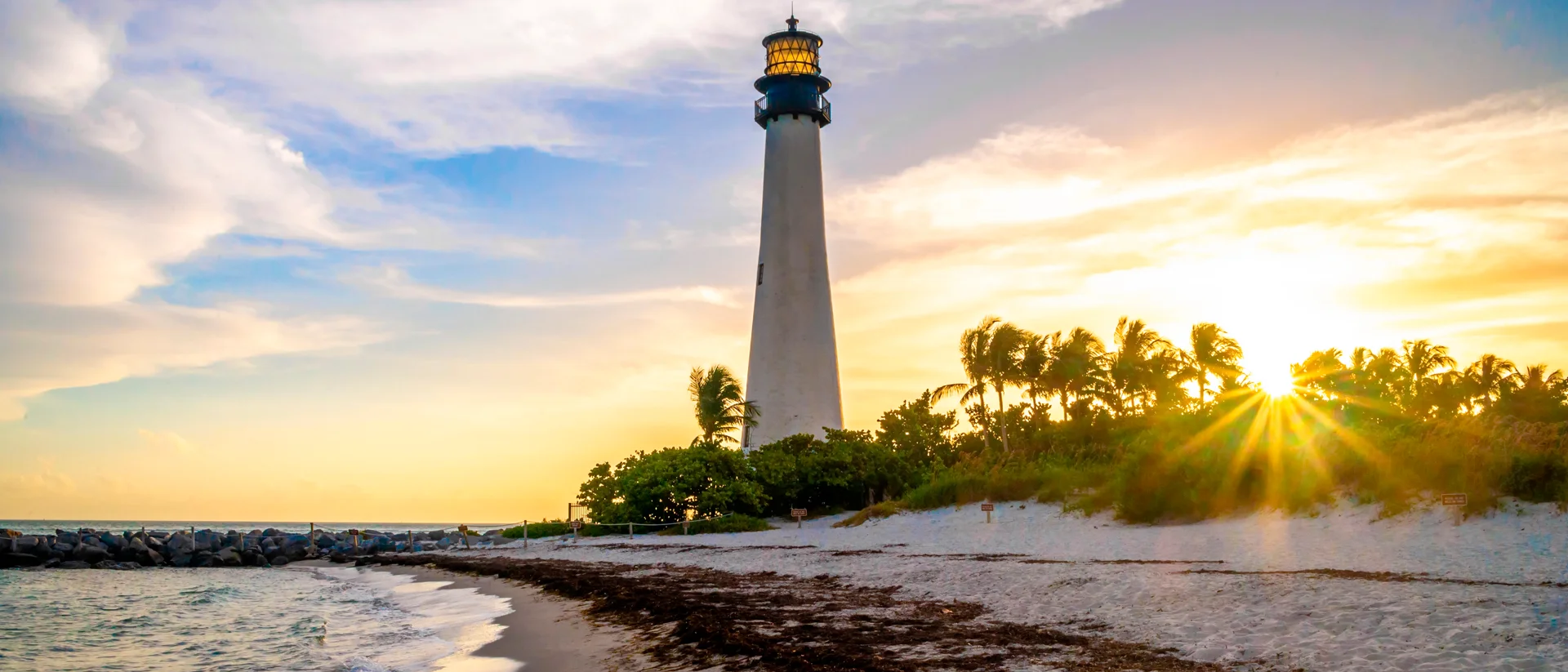 Americas lighthouse beach palms at sunset