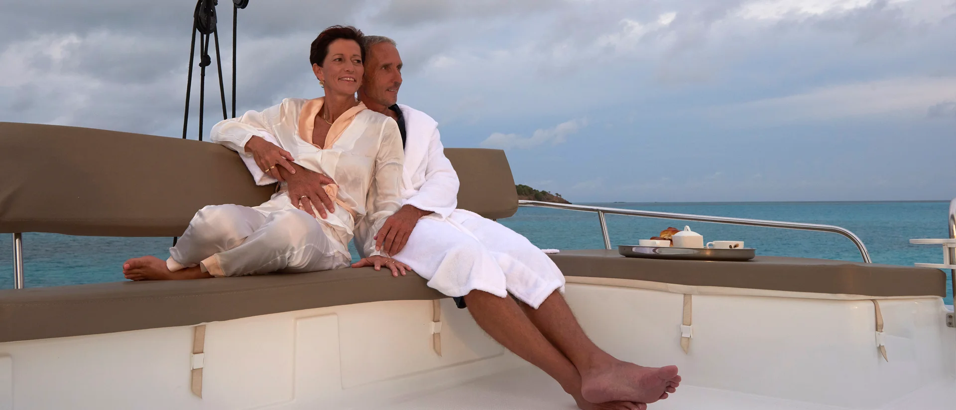 Couple sur un bateau de location avec équipage Premium au coucher du soleil