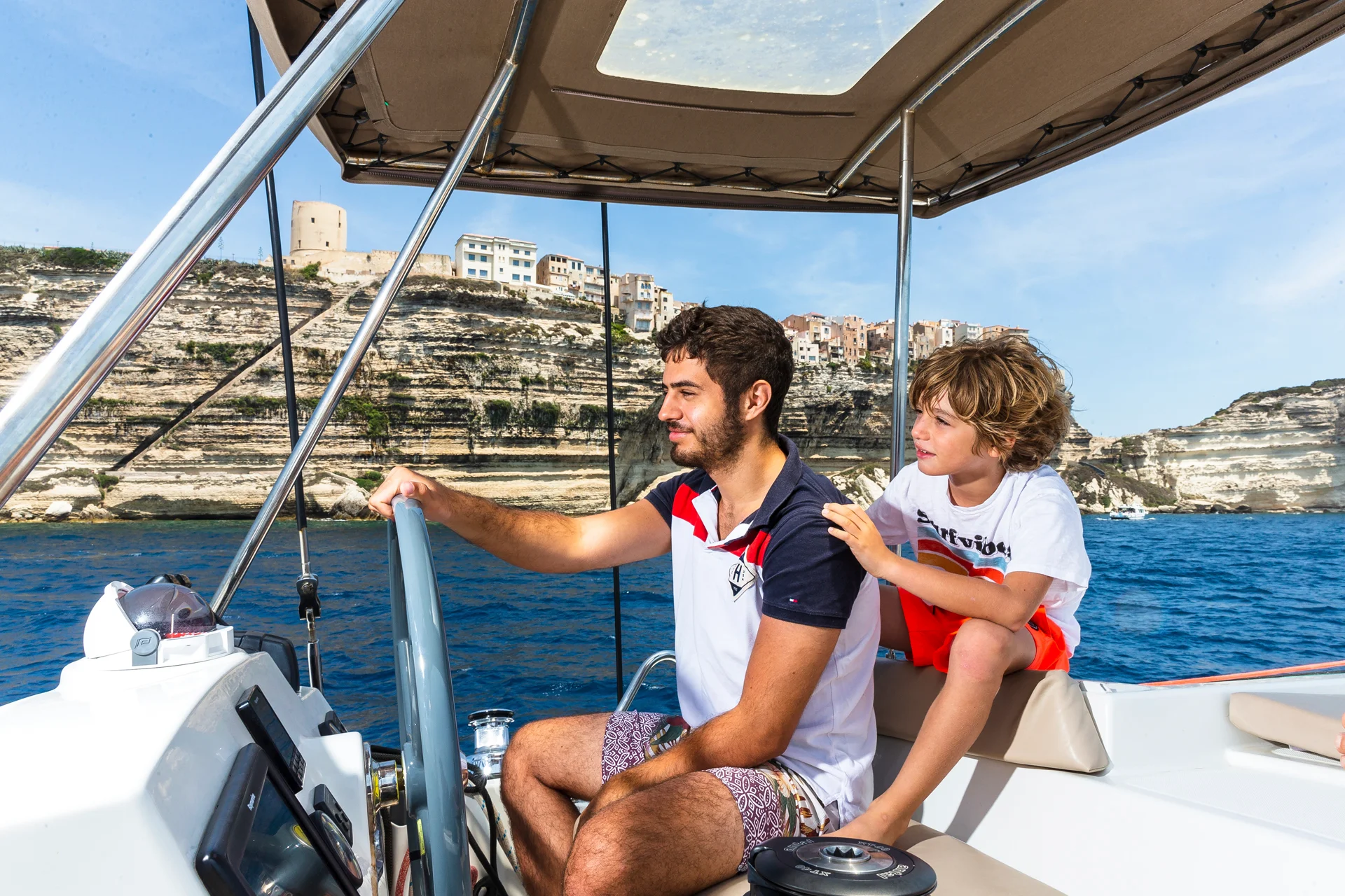 Father and son sailing in a yacht charter
