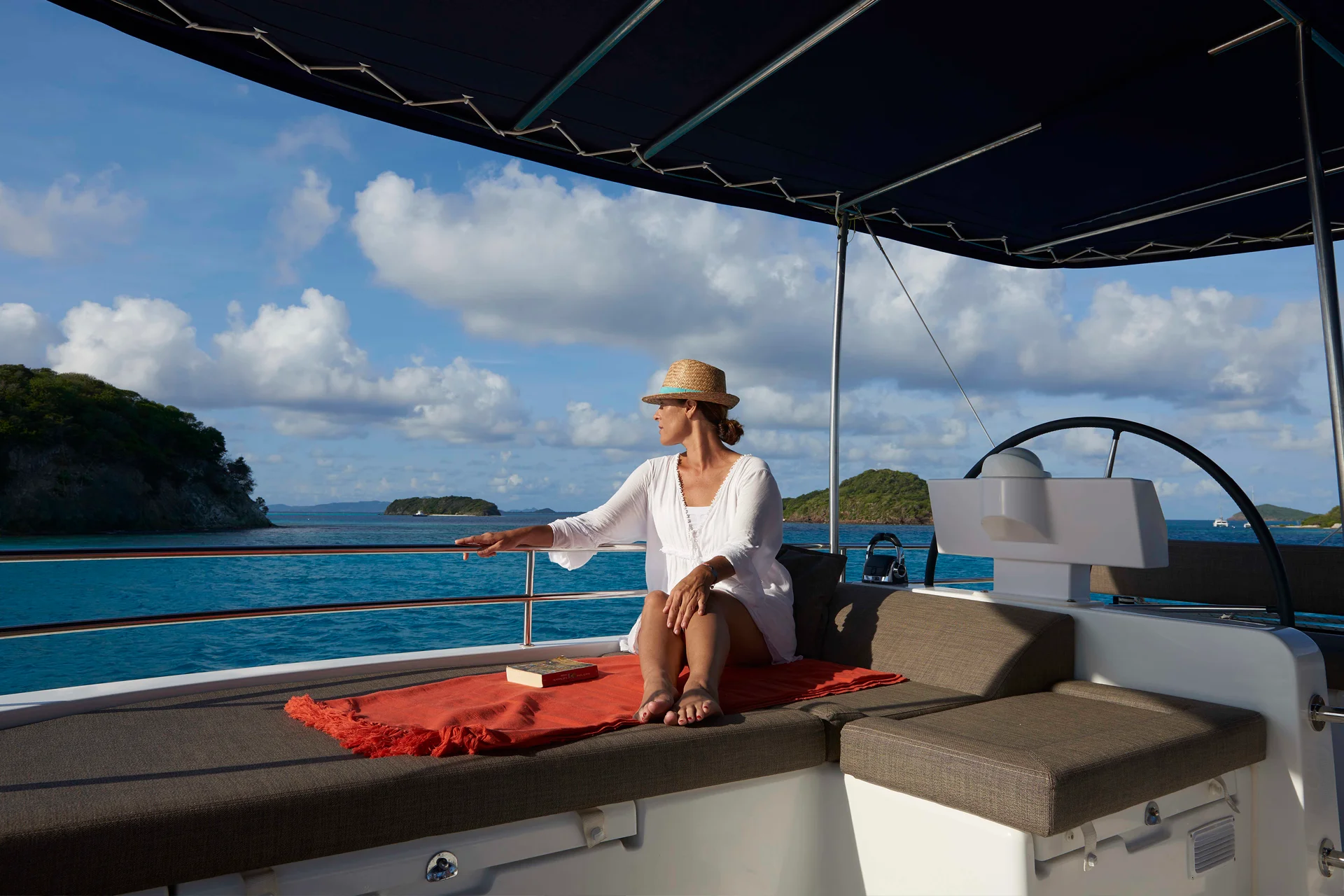 Gast genießt Segeltörn auf einer Yachtcharter mit Crew in der Nähe einiger Inseln