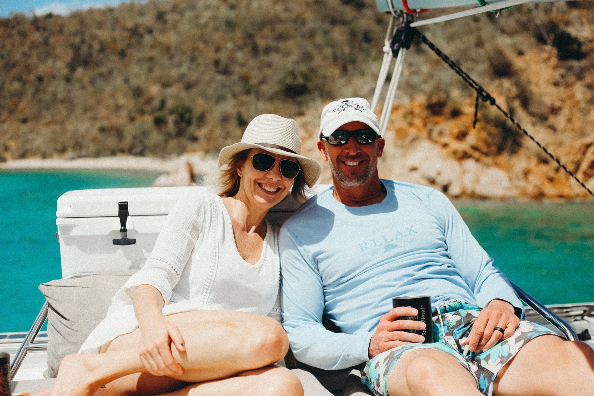 Una feliz pareja sonriendo a bordo de un yate de alquiler con patrón