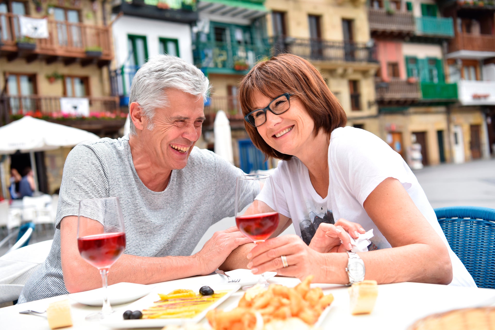 Par som njuter av en medelhavsmåltid och vin på semester