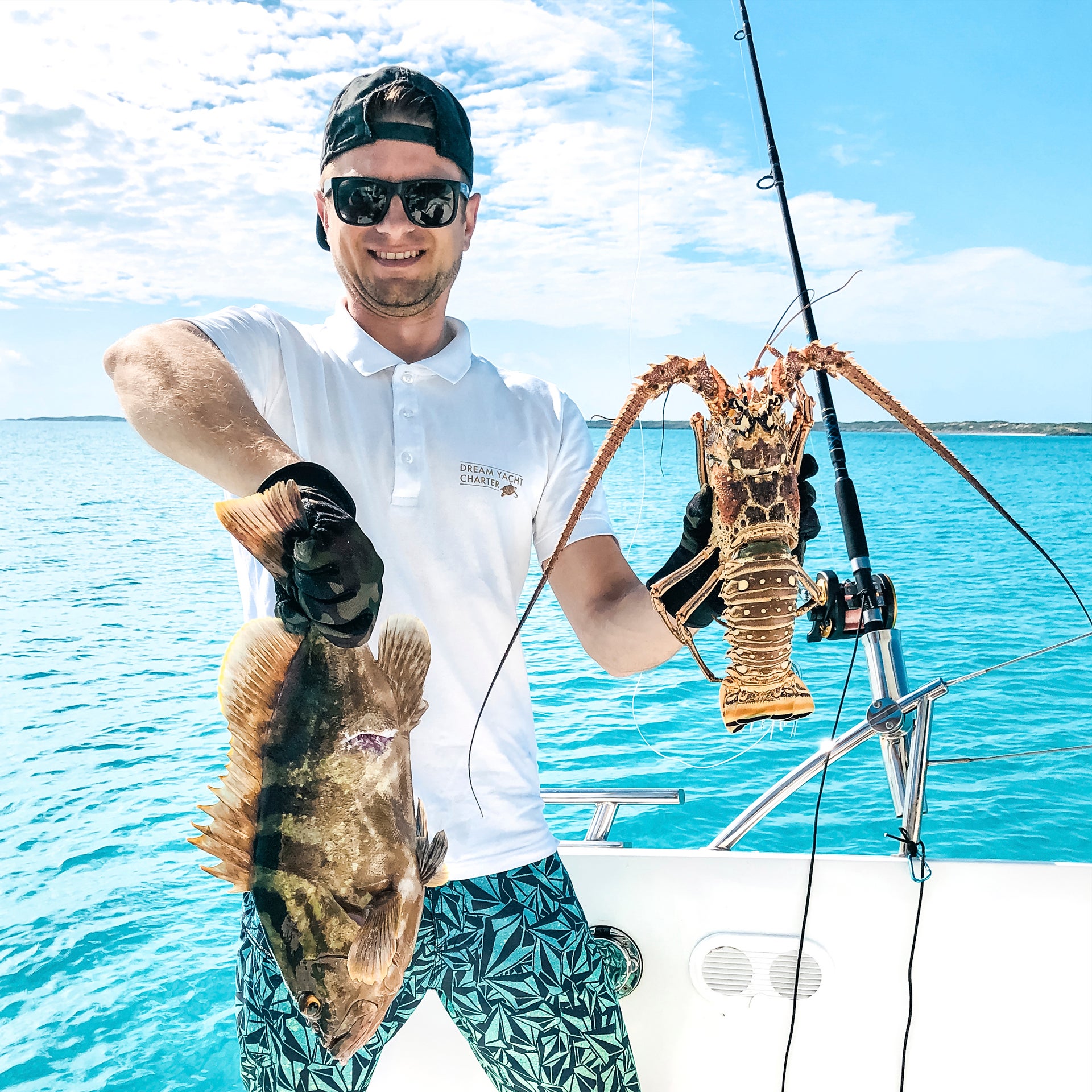 Gast auf Yachtcharter mit Skipper angelt Fisch und Hummer auf den Bahamas