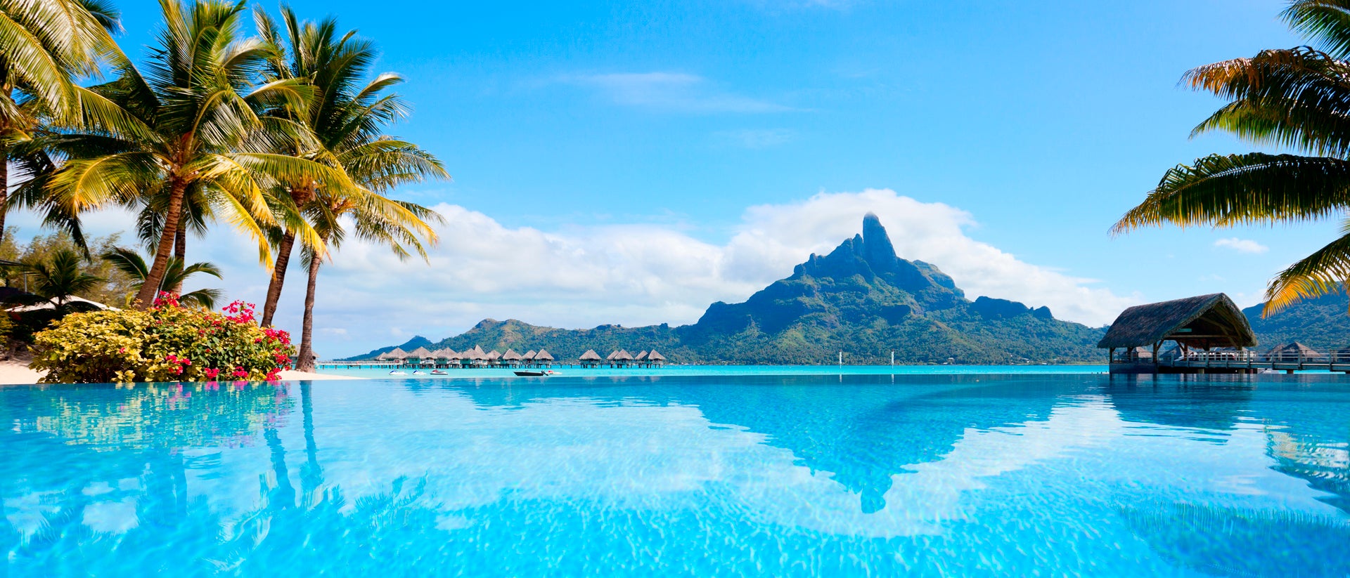 Magnifico paesaggio di Tahiti con capanna sulle acque cristalline e un'isola verde