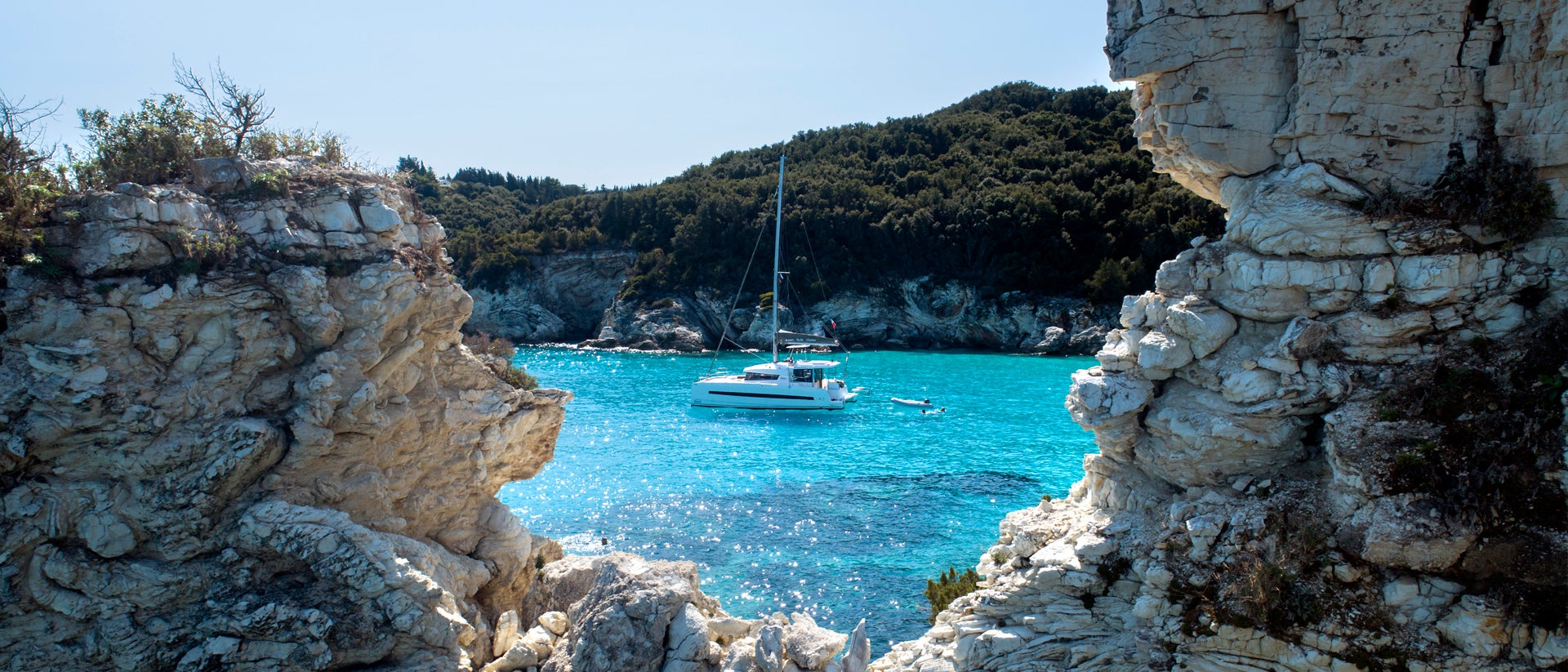 Greek bay with crystal waters and anchored yacht charter