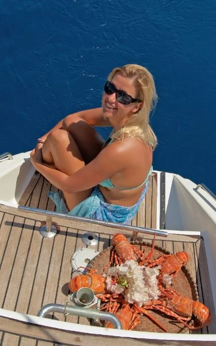 Woman enjoying meal on board of a crewed yacht charter