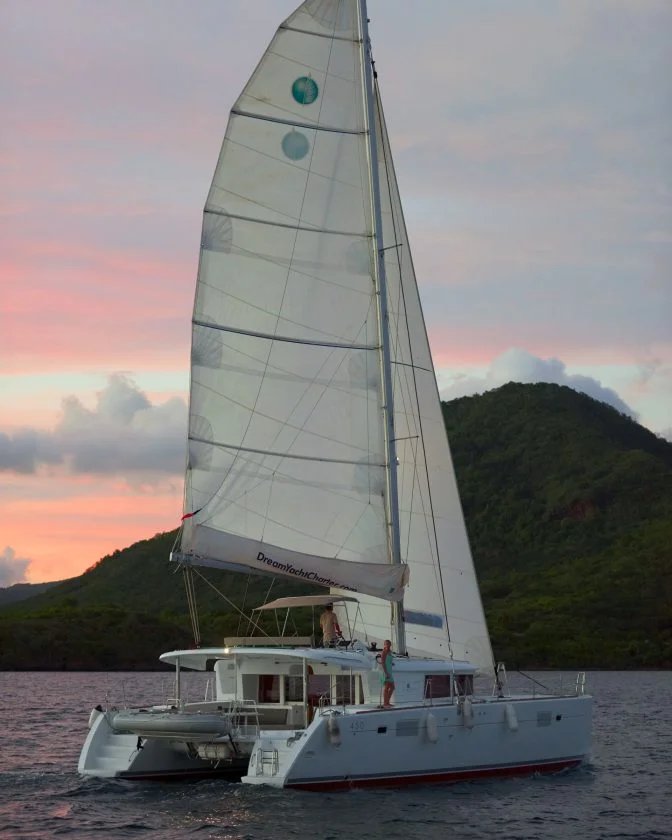 Catamaran charter sailing at sunset