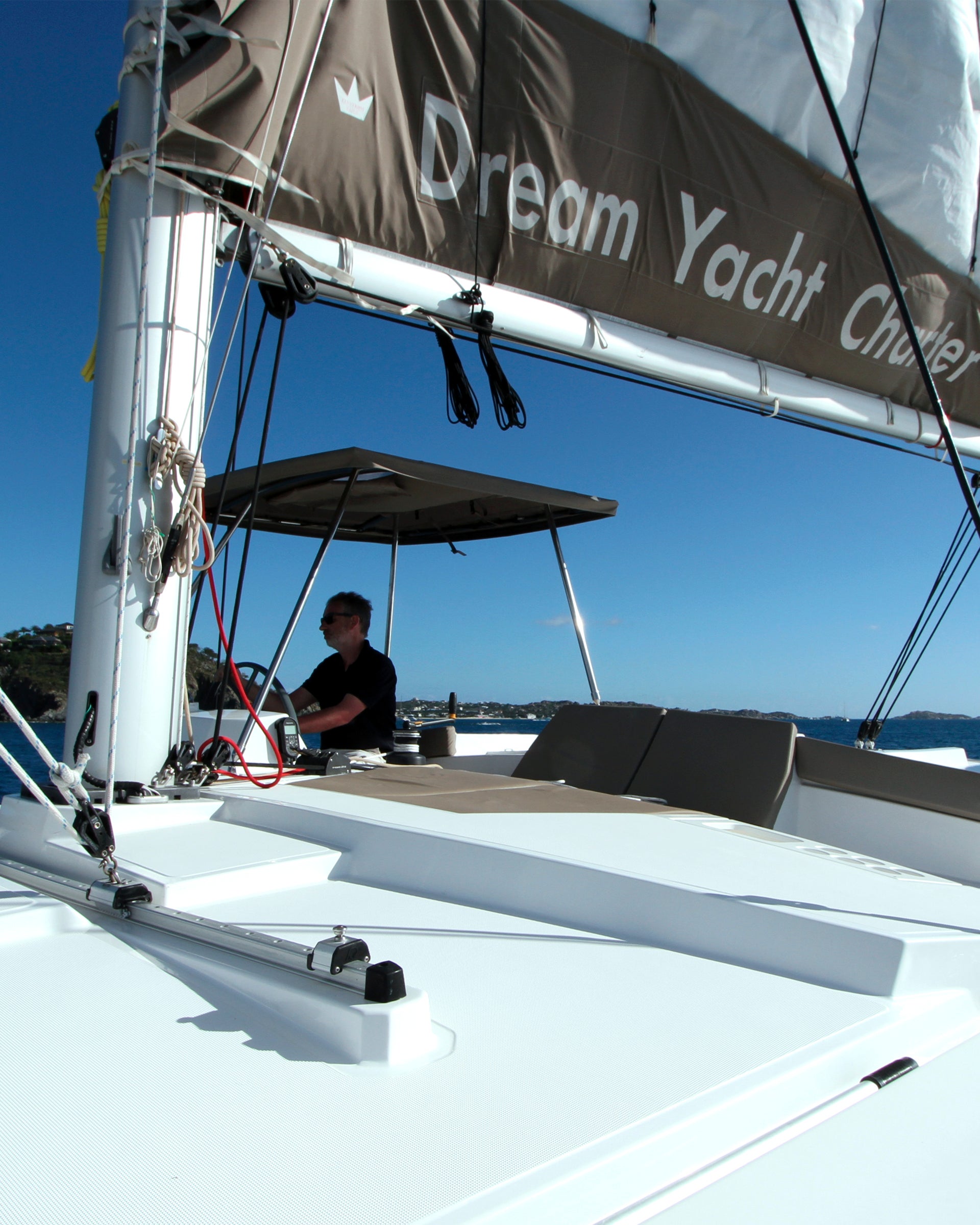 Skipper che conduce una barca a vela e un'isola