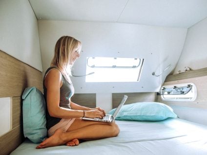 Woman and computer in cabin of a yacht charter