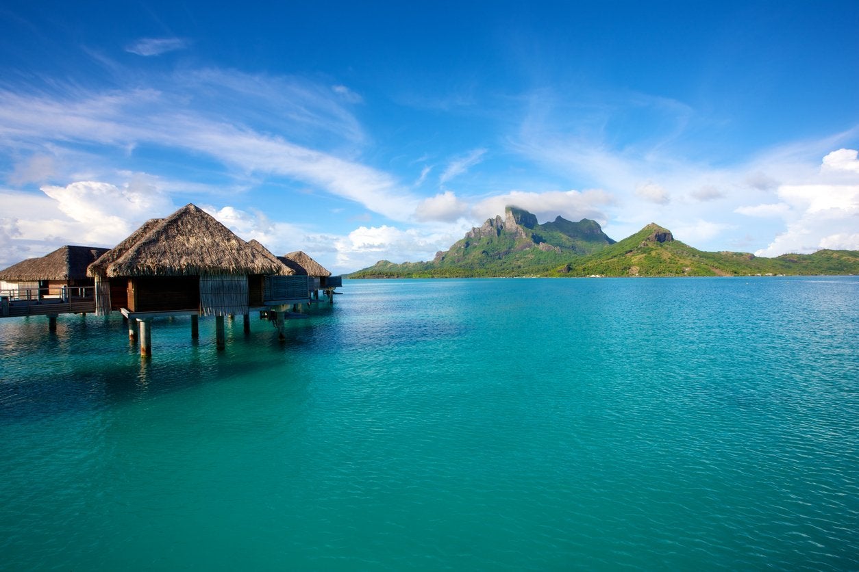 Cabines sur des eaux bleues à Tahiti autour des îles verdoyantes