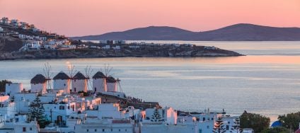 view of houses stores and the water of windmill Bay Mykonos Greece