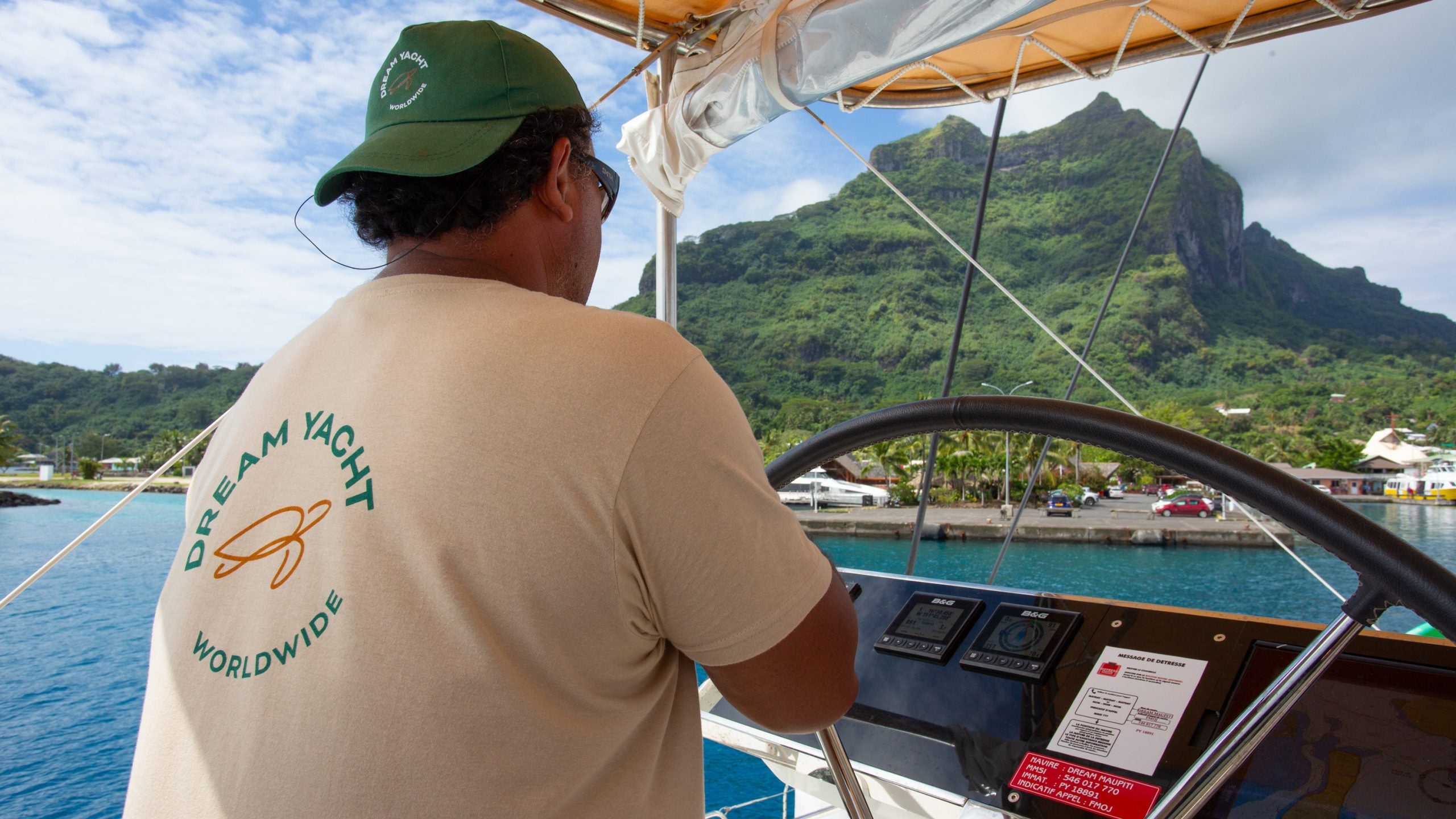 Skipper am Steuer bei einem Yachtcharter-Urlaub auf Tahiti
