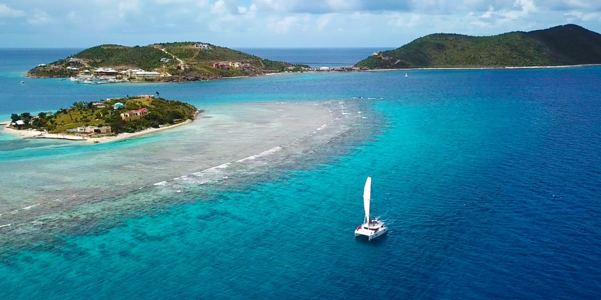 Aerial view of a BVI beach with a catamaran